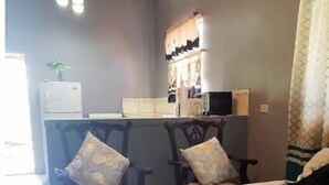 Una sala de estar con un sofá, dos sillones, una mesa de centro y un televisor.