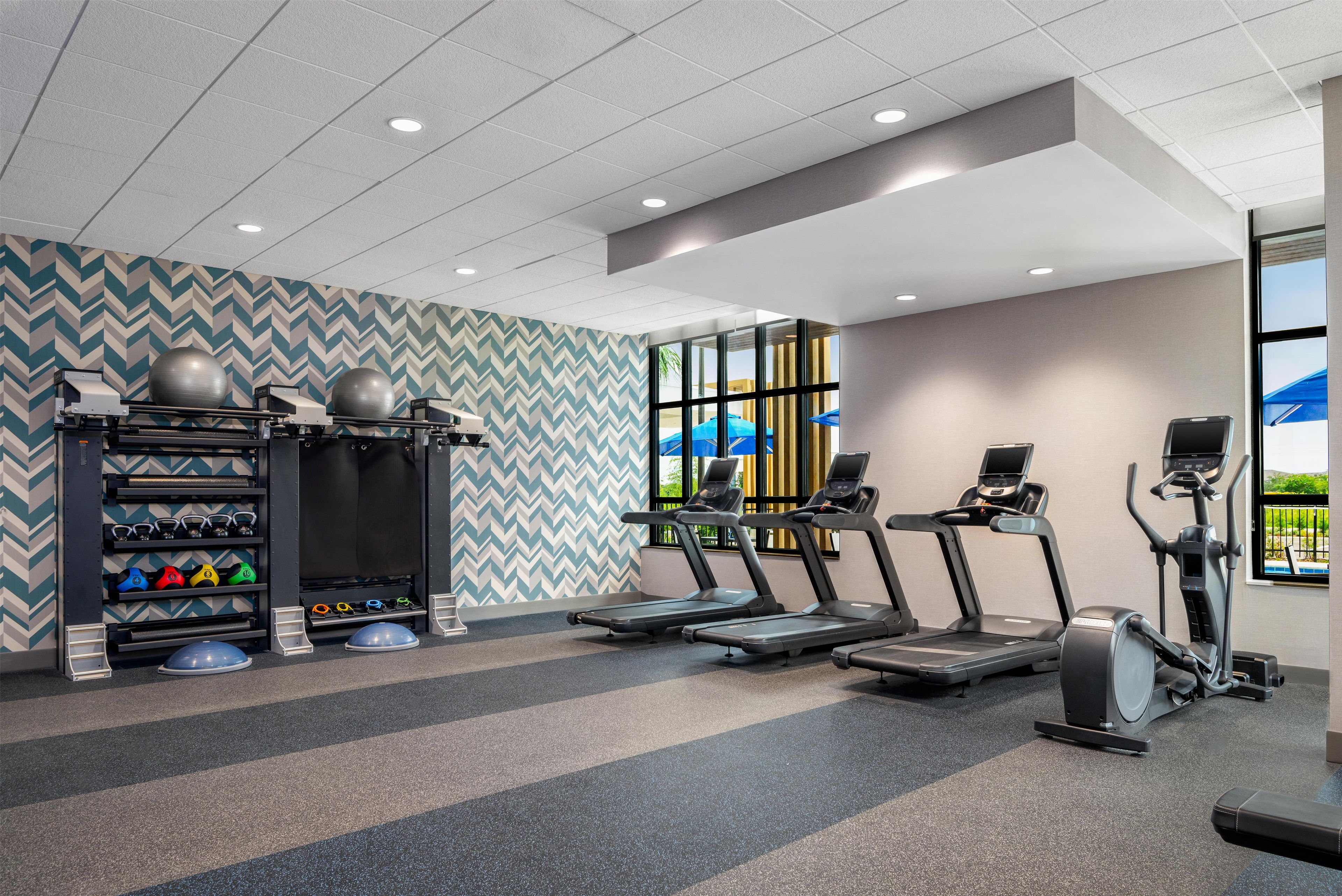 A gym with treadmills, elliptical machines, and weightlifting equipment.