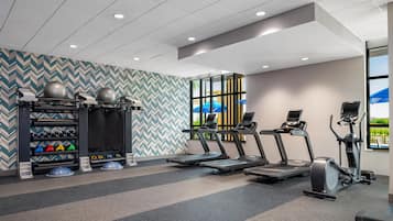A gym with treadmills, elliptical machines, and weightlifting equipment.