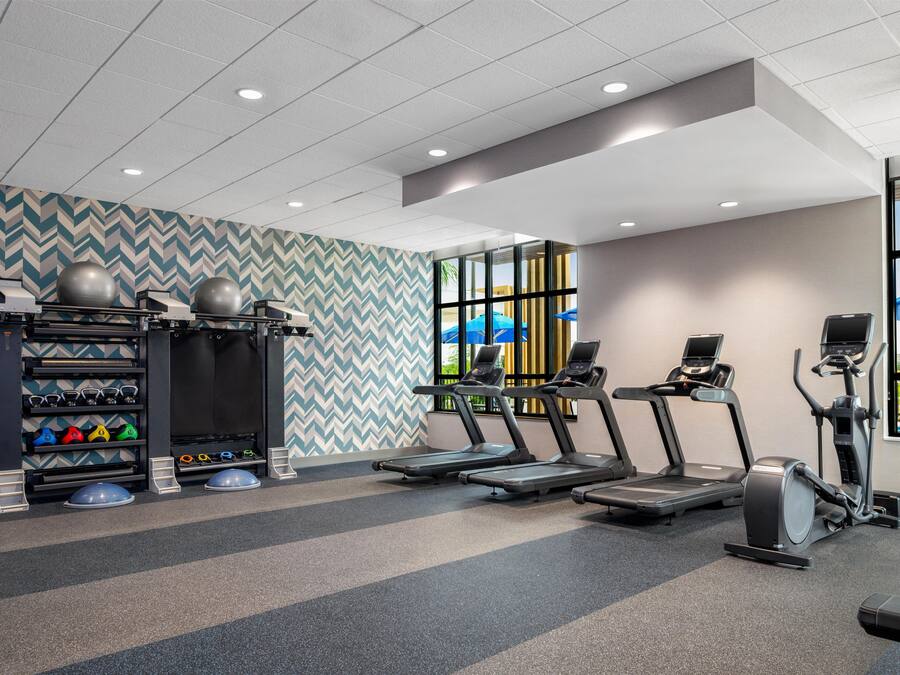A gym with treadmills, elliptical machines, and weightlifting equipment.