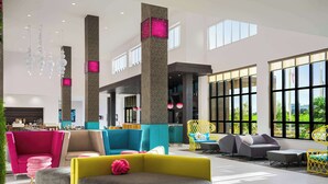 Un hall espacioso con asientos modernos, ventanas amplias e iluminación decorativa.