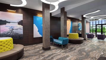 Una hall moderna con zone relax, opere d'arte di grandi dimensioni e pavimento in marmo.