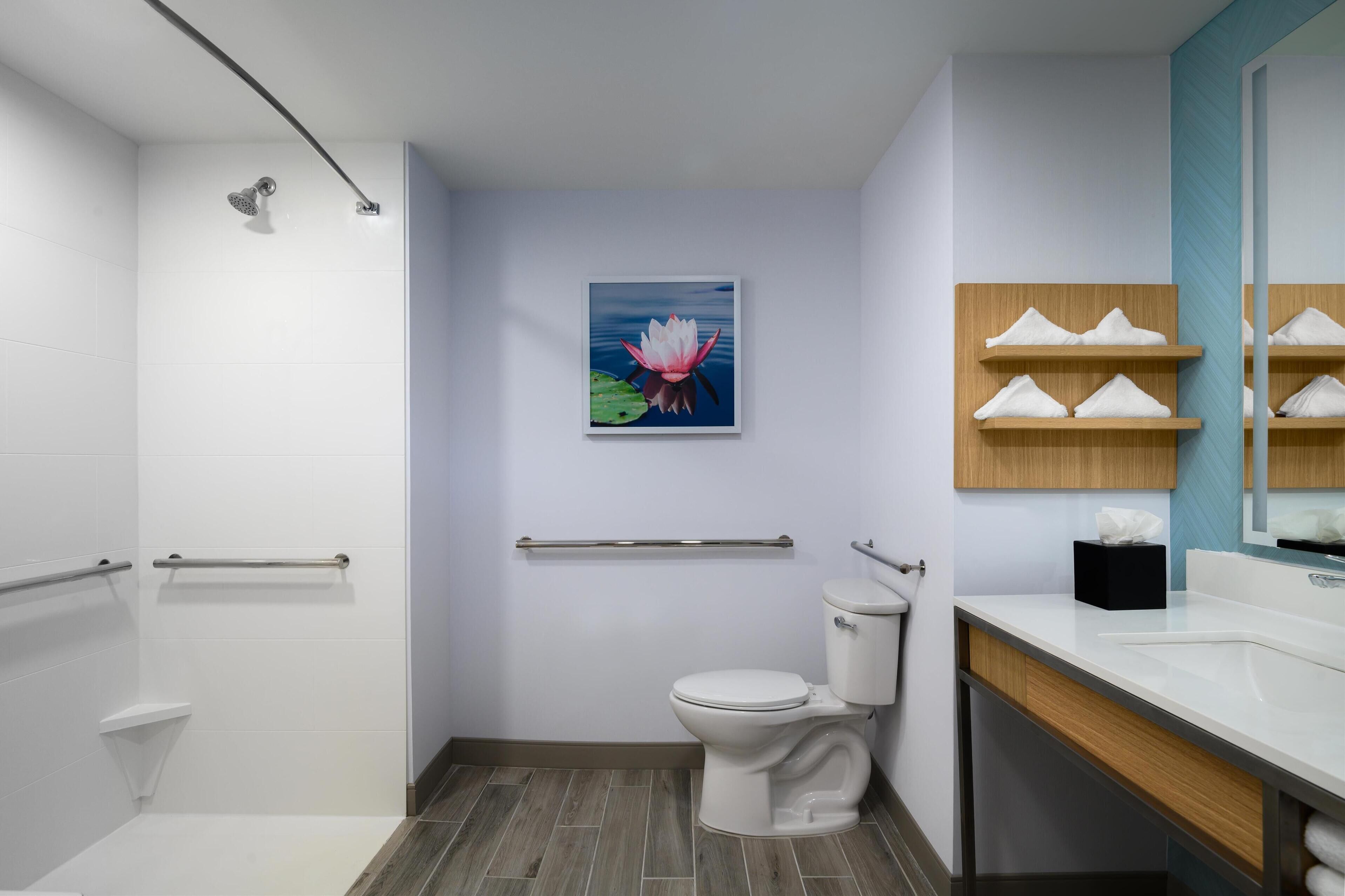 Un baño moderno con ducha, inodoro y lavamanos.