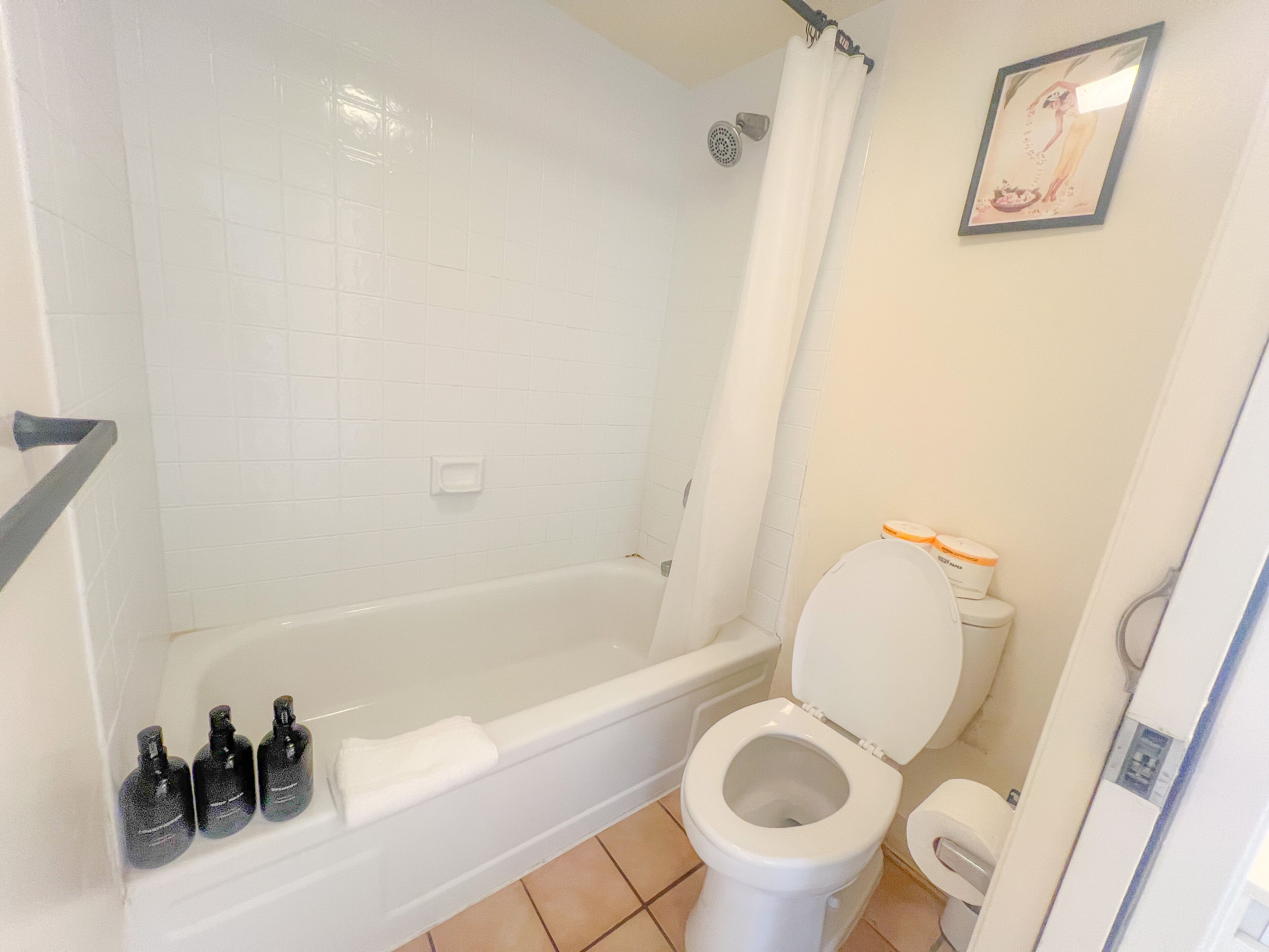 Un baño con bañera, inodoro y cortina de ducha.