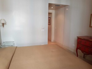 Quarto com cama, penteadeira e abajur.