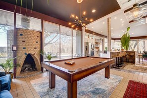 Relax and socialize in this well-appointed space featuring a pool table, brick fireplace, and comfortable seating.