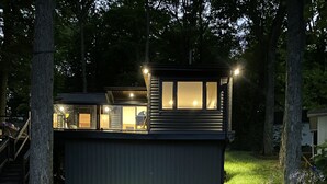 Ett modernt hus med en veranda och en välskött gräsmatta.