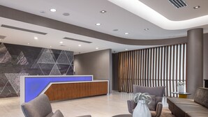 A modern lobby with a reception desk, seating area, and large windows. - SpringHill Suites Tucson at The Bridges (Tucson)