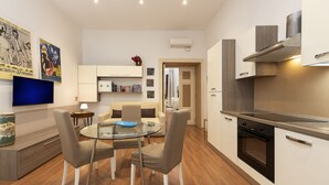 A modern apartment with a dining area, kitchenette, and living space. - Babuino Deluxe - Spanish Steps (Rome)