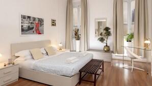 A modern hotel room with a bed, bedside tables, a desk, and a chair. - Babuino Deluxe - Spanish Steps (Rome)