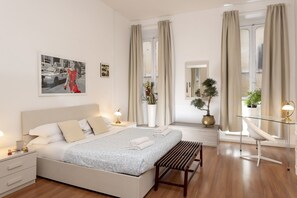 A modern hotel room with a bed, bedside tables, a desk, and a chair. - Babuino Deluxe - Spanish Steps (Rome)