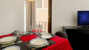 A dining table set with plates, glasses, and a red tablecloth. - Saint Caterina House - Campo de Fiori (Rome)