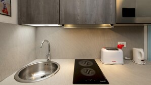 A modern kitchen with a stainless steel sink, a toaster, and a kettle on the counter. - Saint Caterina House - Campo de Fiori (Rome)