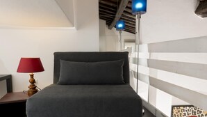 A modern room with a bed, a red lamp, and a blue hanging light fixture. - Saint Caterina House - Campo de Fiori (Rome)