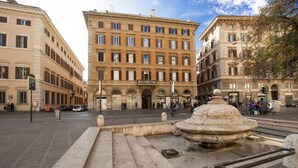 A public square with a fountain, historic buildings, and a tram line. - Corso Vittorio - Campo de Fiori (Rome)