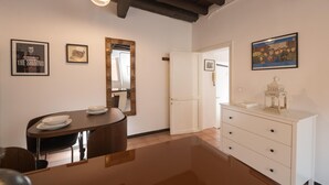 Ein Essbereich mit einem Holztisch, Stühlen, einem weißen Schrank und einem Spiegel an der Wand.
