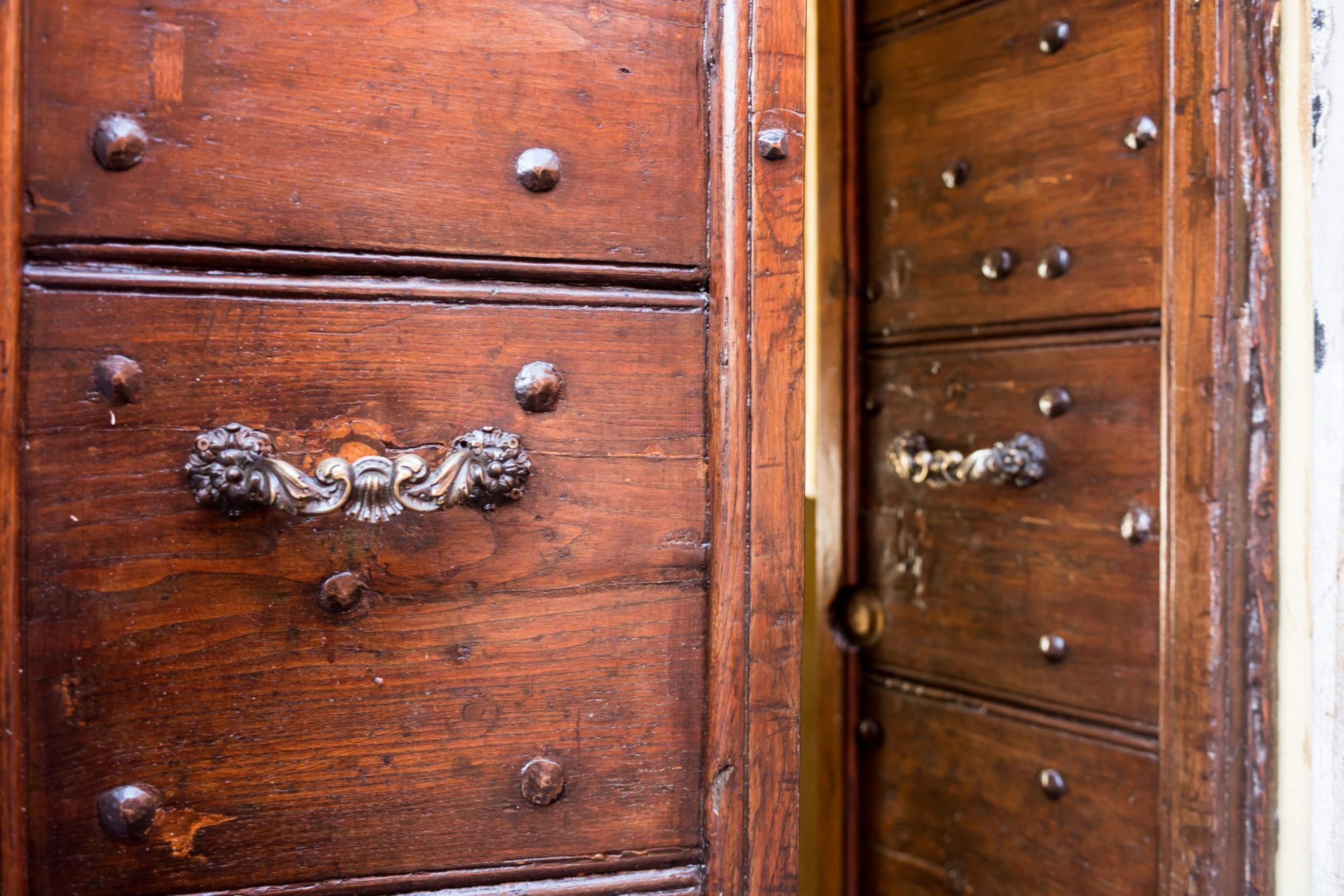 A wooden cabinet with metal knobs and a decorative handle.