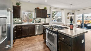 A modern kitchen with dark wood cabinets, stainless steel appliances, and a large island.