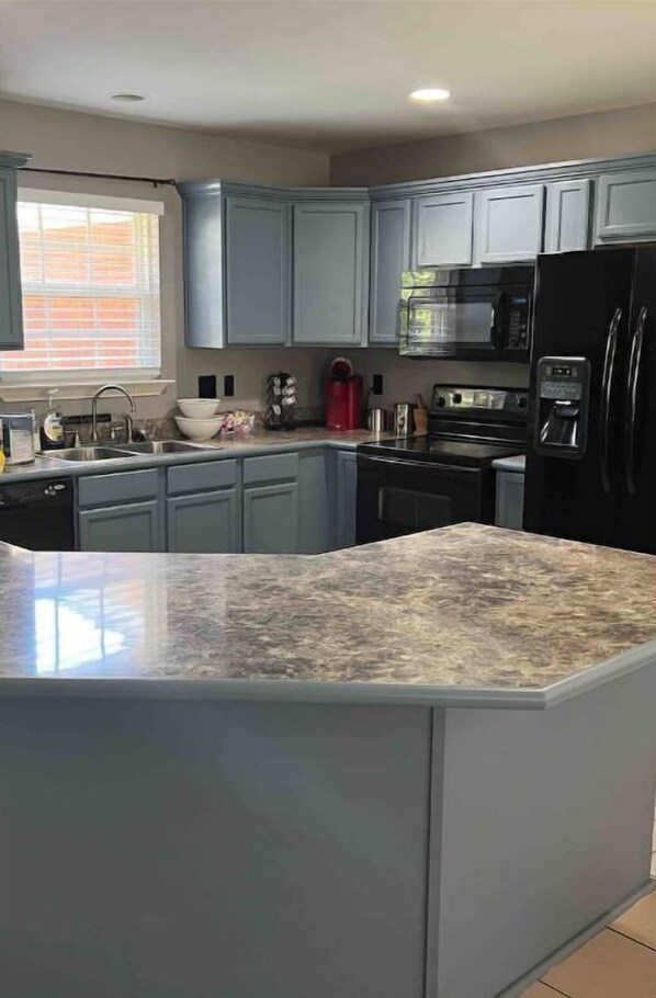 Enjoy cooking in this well-equipped kitchen with a refrigerator, microwave, and stove, and take in the view from the window.