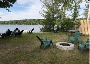 Une terrasse au bord du lac, dotée de sièges extérieurs et d’un foyer.