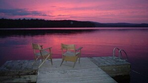 A wooden dock with two chairs facing a calm lake at sunset. - Haskell's Lodge on Long Pond! (Belgrade)