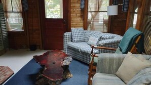 A cozy room with a checkered sofa, a wooden coffee table, and a blue carpet. - Mystic Bungalow (Belgrade)