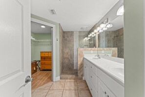 Une salle de bain moderne avec un double vasque, un grand miroir et une douche à l’italienne.