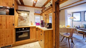 A kitchen with wooden cabinets, a stove, and a coffee maker.