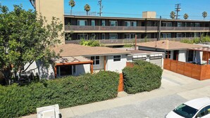 A multi-story motel with a flat roof, multiple balconies, and a parking area. - PB Dream HOUSE Steps to Beach Bay ❤️Modern Private (San Diego)