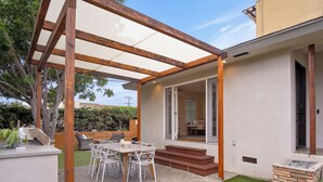 A patio with a table and chairs, a wooden pergola, and a view of the house. - PB Dream HOUSE Steps to Beach Bay ❤️Modern Private (San Diego)