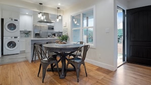 A modern kitchen with a central island, built-in appliances, and a dining area with a round table and chairs. - PB Dream HOUSE Steps to Beach Bay ❤️Modern Private (San Diego)