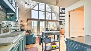 Een moderne keuken met een groot raam, een eethoek en een trap.