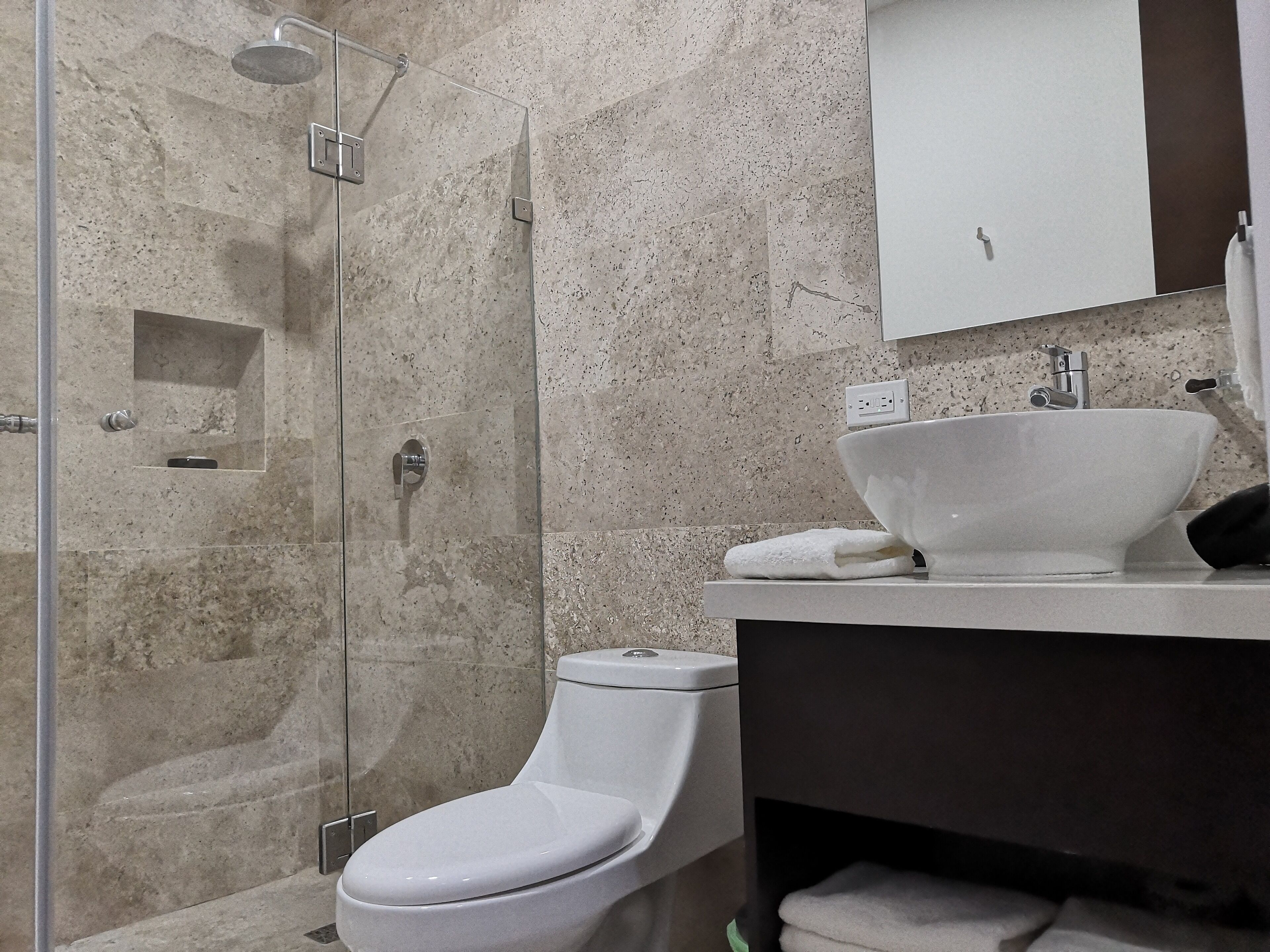 Une salle de bain équipée d’une douche, de toilettes, d’un lavabo et d’un porte-serviettes.