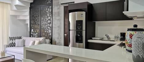 A modern kitchen with a central island, stainless steel appliances, and a decorative vase.