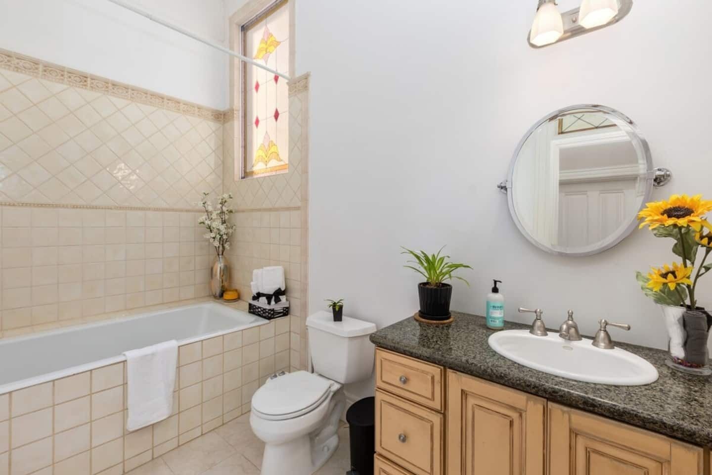 A bathroom with a bathtub, toilet, sink, and vanity.