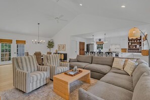 Relax in this spacious living room with a large sectional sofa, armchairs, and a dining area.