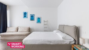 A bedroom with a large bed, a smaller sofa, and a ladder against the wall. - Largo Molina Studio III by Wonderful Italy (Bologna)
