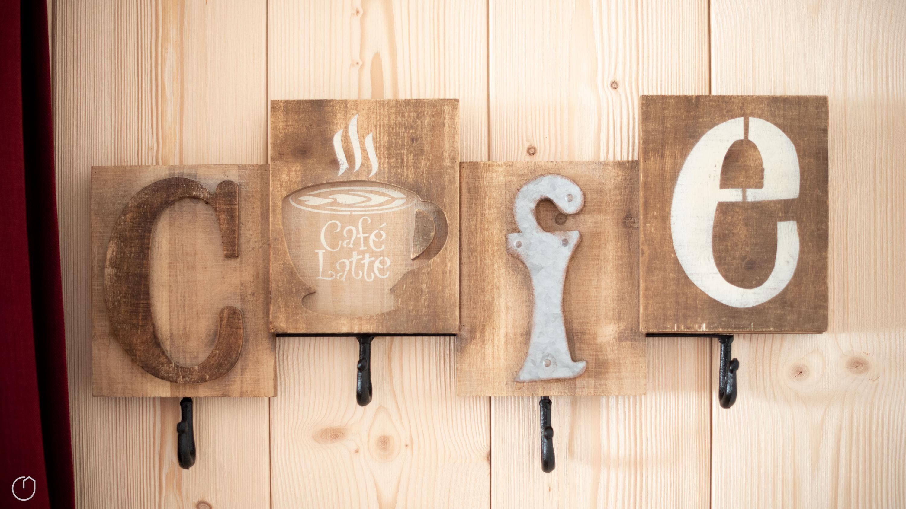 Wooden signs with letters 'C', 'e', and 'e' on a wall.
