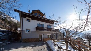 A two-story building with a balcony, a chimney, and a satellite dish.