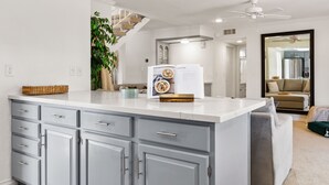 A modern kitchen with grey cabinets, a white countertop, and a built-in oven.