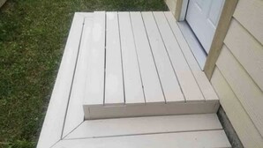 Una serie de escalones blancos de madera que llevan a una puerta.