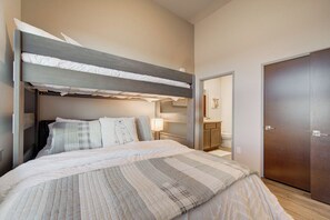 A bunk bed with a headboard, a bedside table with a lamp, and a wardrobe. - Yellowstone Country | Mountain Views | Walk to MSU (Bozeman)