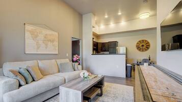 A modern living room with a sofa, coffee table, and a world map on the wall.
