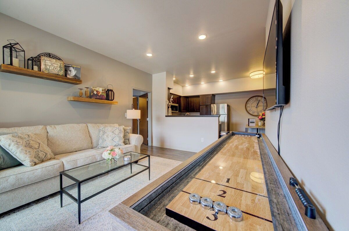 A living room with a shuffleboard table, a sofa, and a coffee table.