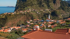 Un village côtier avec des maisons à étages, une église imposante et une falaise abrupte.