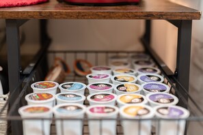 Una estantería metálica con varios recipientes de helado.