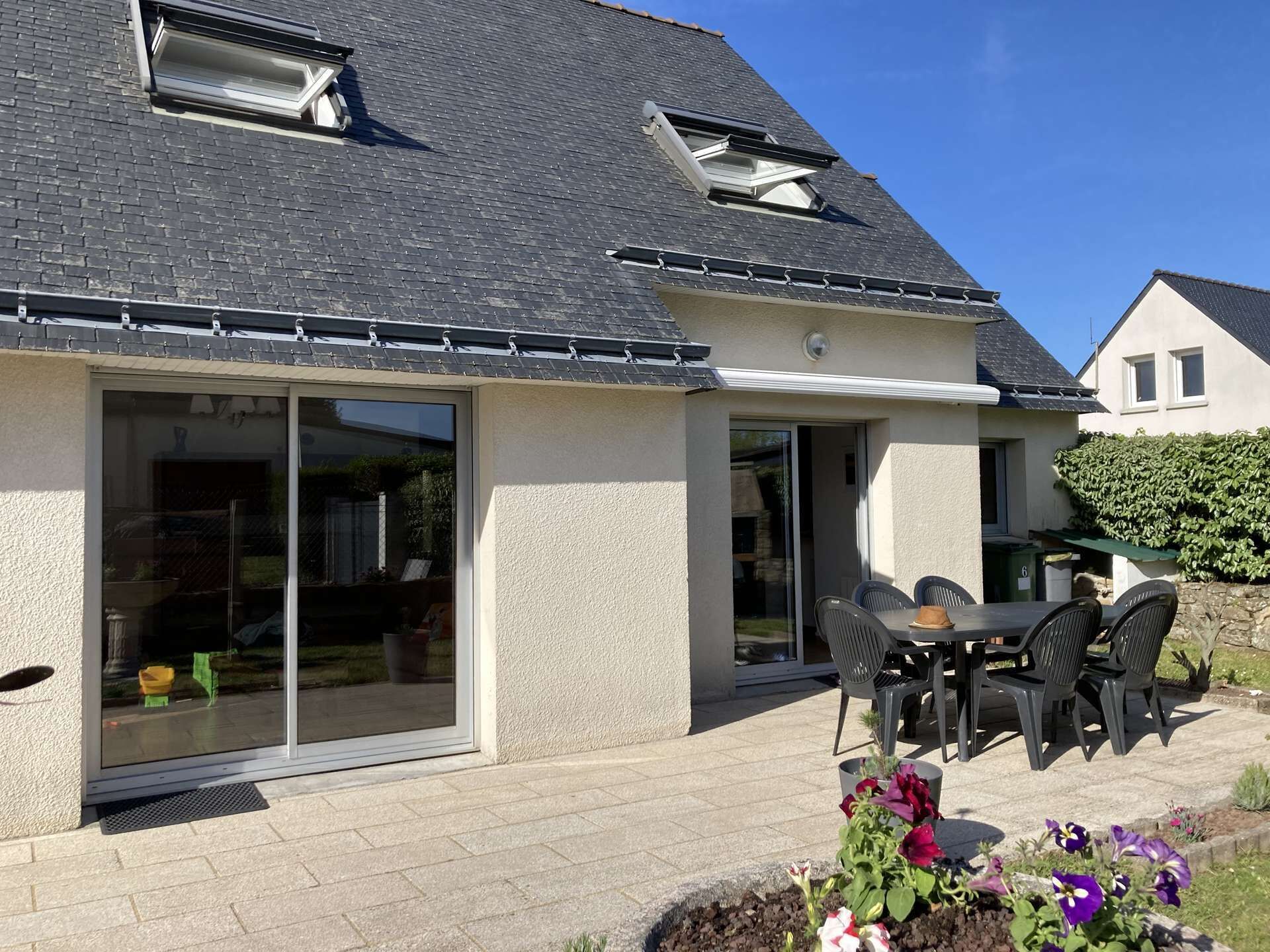 A house with a patio area, a sliding glass door, and a small outdoor table with chairs.