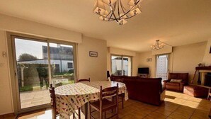Un amplio salón con una mesa de comedor, sofá y televisor.