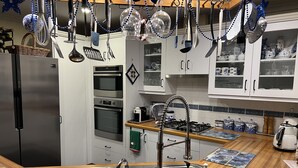 Una cucina moderna con elettrodomestici in acciaio inossidabile, un piano di lavoro in legno e un lavello.