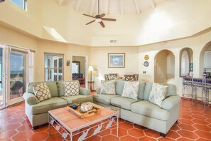 Relax in this stylish living area with a high ceiling, light-colored floor, and comfortable sofa.